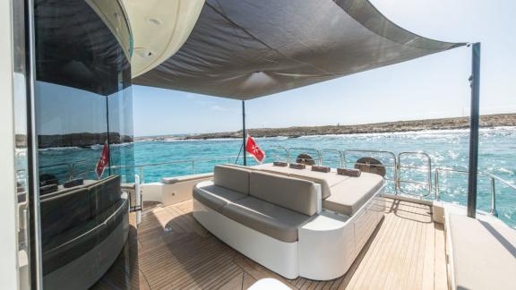 The aft deck of motor yacht Aya One features a spacious shaded seating area.