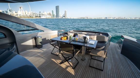 The aft deck of the Pershing 70 offers an exclusive outdoor dining area for a luxury Dubai yacht rental experience.