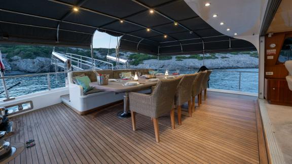 Luxus-Gulet-Charter in der Türkei mit stilvollem Essbereich auf dem Deck und entspannter Atmosphäre am Wasser.