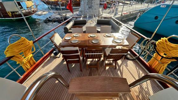 The aft deck of Gulet Ahmet Ertürk features a large dining table and comfortable seating areas.