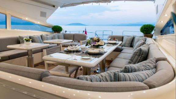 Zu sehen ist der großzügige U-Sitzbereich am Heck der Atrato in Athen mit Esstisch.