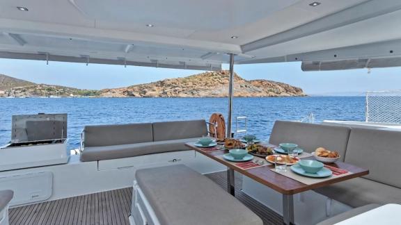 Helidoni charter catamaran offers breakfast setup with a stunning sea view.