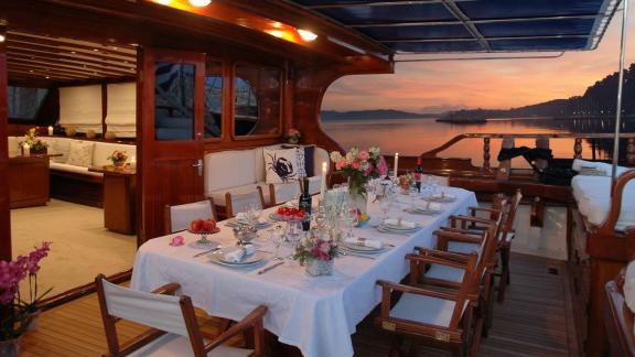 An elegantly laid dining table on the deck of the gulet Matina in Greece