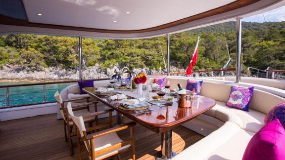 The cosy dining area of the gulet Queen of RTT in Fethiye offers a large table with comfortable chairs and cushions