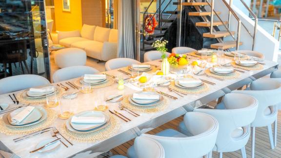 Auf dem Deck der Renata sorgt ein stilvoll gedeckter Tisch mit elegantem Geschirr für unvergessliche Abendessen.