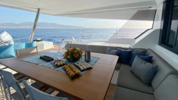 Allure catamaran for rent serves refreshments with a sea view on the aft lounge.