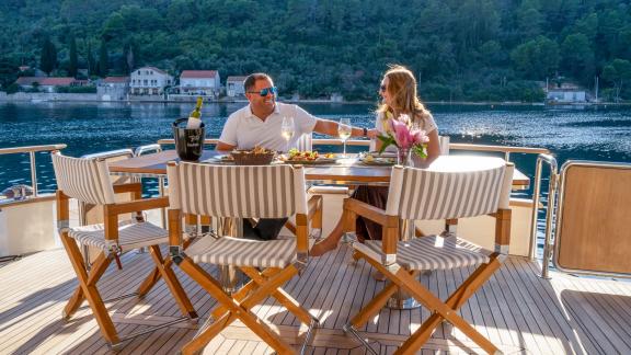 A refined dining moment awaits aboard the Menorquin 68 FB motor yacht Cloud 9, set on the aft deck with sweeping coastal