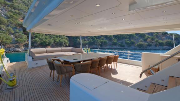 Anchored in Fethiye bays the 6 cabin 12 guest Dodo motorsailer featuring aft deck dining table and lounge seating.