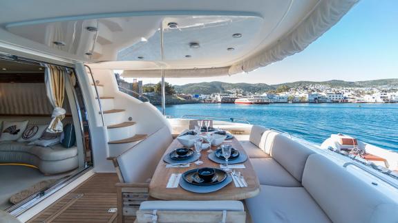 The aft deck of the Edition yacht features an elegant dining area with a sea view and comfortable seating arrangements.