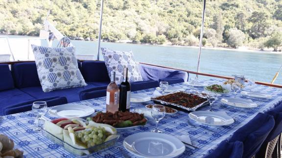 Gedeckter Tisch auf dem Achterdeck der Sumru Sultan mit Meerblick, ideal für ein elegantes Essen.