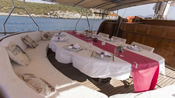 Tastefully laid dining table with red runner, surrounded by comfortable seating.