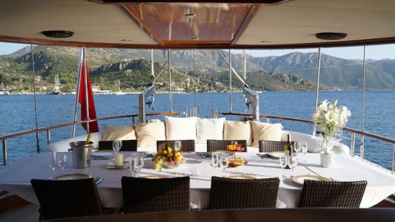 Enjoy an elegant dinner with mountain views aboard the Gulet İlknur Sultan in Fethiye.