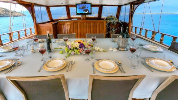 An elegantly set dining table on the Su Sesi gulet, ready for a special dinner with sea views.