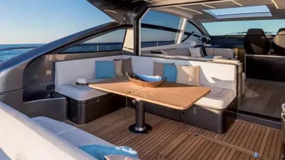 The spacious seating area of motor yacht Urus features comfortable cushions and a modern table.