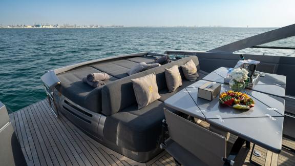 The aft deck of the Pershing 70 combines lounging and dining spaces for your Dubai daily yacht rental experience.