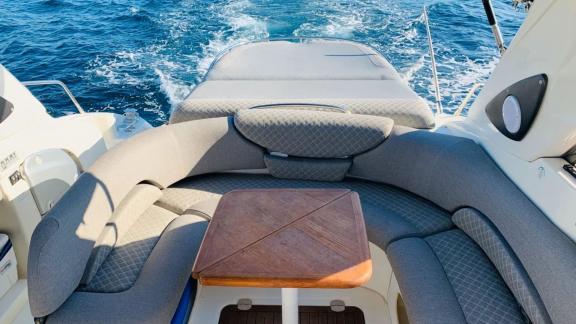 Der Sitzbereich am Heck der Motoryacht Com Tu mit Blick auf das Meer bei Fahrt in Ibiza.