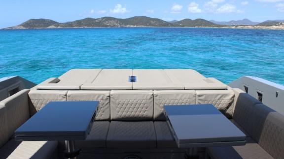 Backside lounge and dining zone of daily motor yacht Bambino off Ibiza coast.