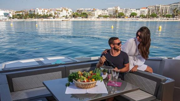 A couple opens champagne on the back deck with Mallorca’s scenic coast in view.