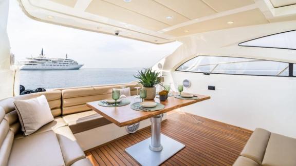Auf dem offenen Deck der Motoryacht Aron 26 befindet sich ein stilvoller Essbereich mit Meerblick.