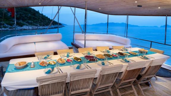 Genießen Sie ein luxuriöses Abendessen an Bord der Gulet Anıl Kaptan 1 mit atemberaubendem Meerblick.