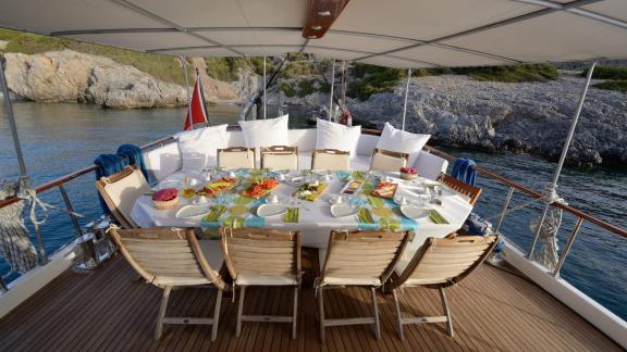 Beautifully set outdoor dining area on the Gulet Sıla with views of the scenic coastline.