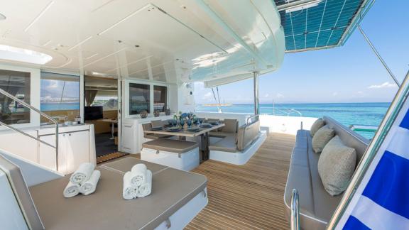 Elegantes Aft-Deck der Lagoon 52F mit Esstisch und Liegeflächen, ideal für entspannten Genuss auf See.