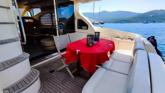 The aft deck of motor yacht Ela offers a comfortable seating area and sea view.