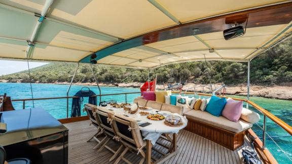 Gemütlicher Außenbereich mit Essbereich und Sitzgelegenheiten auf der Gulet Golden Joy, ideal zum Entspannen in Bodrum.