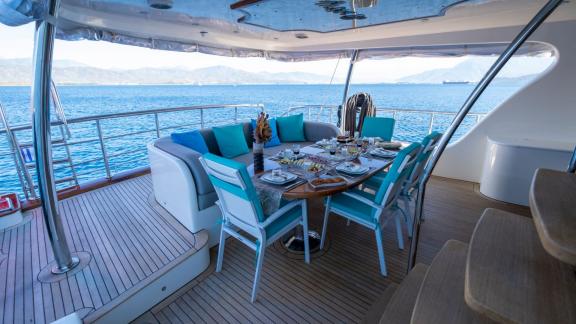 Set dining table in the outdoor area of the gulet with a view of the sea.