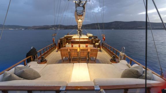 Evening deck view of the gulet yacht Jasemin 1 with cosy seating area and dining table.