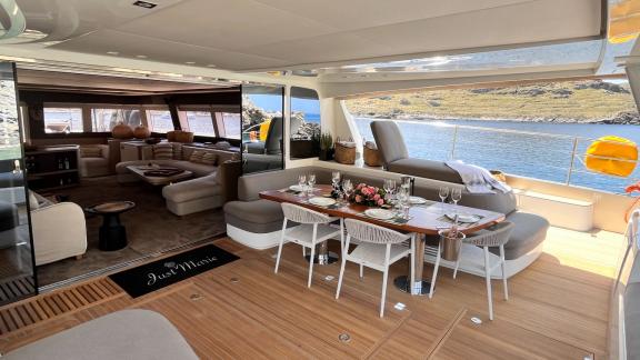 Elegantly set dining area on the Catamaran Just Marie 2, with stunning views of the coast and the sea.