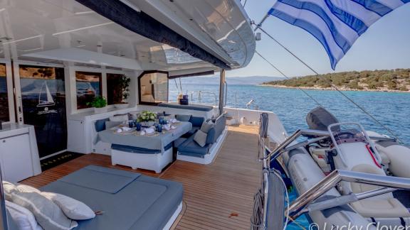 The Catamaran Lucky Clover offers a luxurious outdoor dining area with cozy seating.