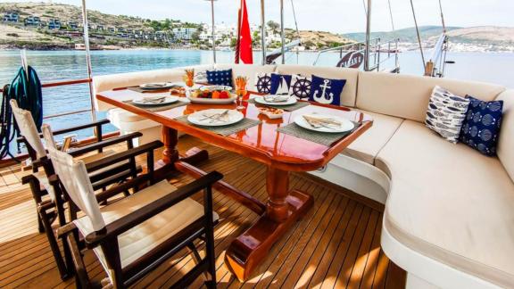 A nautically themed dining table on Gulet Cagan 2, with a view of the coast, perfect for a stylish outdoor meal.