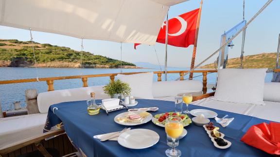 Cozy breakfast table on Gulet Xenos 2 in Bodrum with sea view and delicious food.