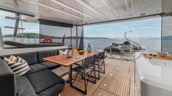 Cozy dining area on the aft deck of the catamaran Princess S with a sea view near Šibenik, Croatia