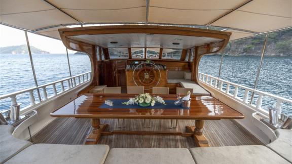 Elegant dining area and helm on the Kayhan yacht, perfect for exclusive sea journeys.