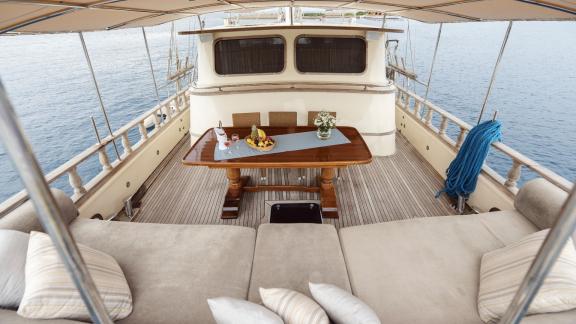 Seating area and dining table on the gulet's outdoor deck, perfect for relaxation.