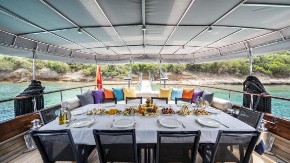 Inviting dining area with colorful cushions on Gulet Golden Glory.