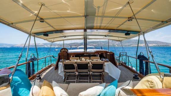 Überdachter Essbereich und gemütliche Lounge mit Blick auf das Meer auf der Gulet Golden Joy in Bodrum.