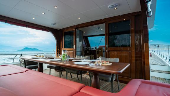 Dining area on the yacht Ok Ay with a set table and panoramic sea view in Fethiye.