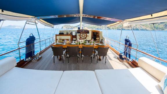 Covered dining area on the Gulet Cemre Mila with views of the open sea and the coast.