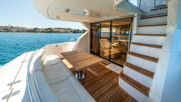 Aft deck of the yacht 2 Drunk with a seating area and stairs leading to the interior.