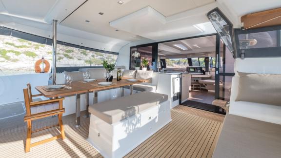 Tastefully furnished outdoor dining area on the catamaran Pi 2 in Athens, perfect for meals with a sea view.