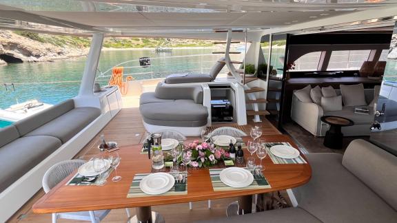 Luxuriously set dining area on the Catamaran Just Marie 2, surrounded by beautiful coastal scenery and calm waters.