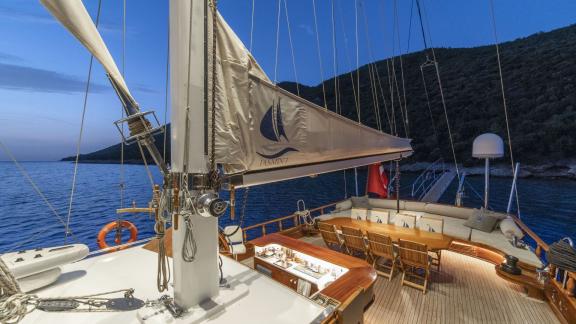 Abendliche Beleuchtung auf dem Deck der Gulet-Yacht Jasemin 1, mit gemütlicher Sitzecke und Esstisch.