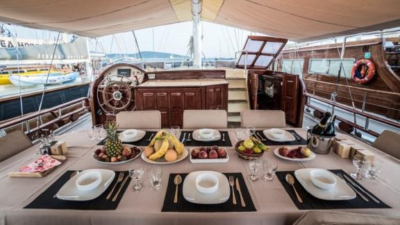 Elegant set dining table with fruit and champagne on the Gulet Optimist in Bodrum.