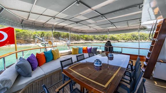 Lounge area with colorful cushions and sea view on Gulet Golden Glory.