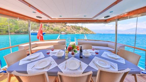 A beautifully set table on the Gulet Kasapoglu 6, ready for dinner with a sea view.