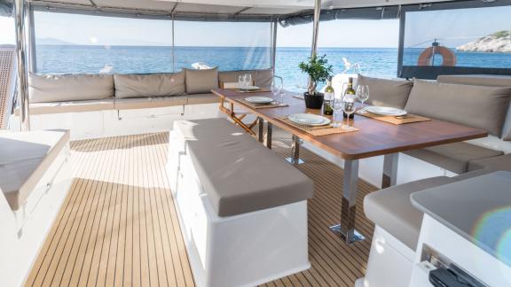 Stylishly set dining area on the catamaran Pi 2 in Athens with a view of the open sea.