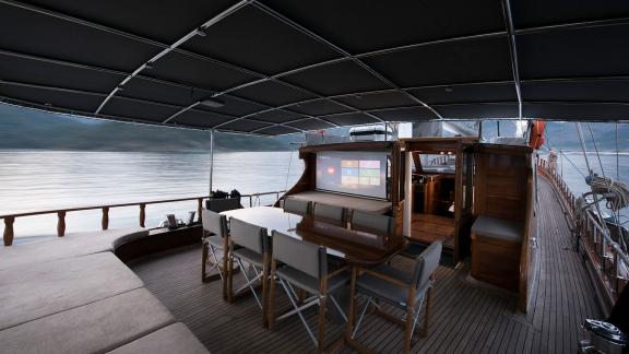 Covered dining area with screen on Serenad A, perfect for evenings on board.